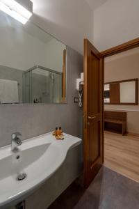 baño con lavabo blanco grande y espejo en Albergo Reggio, en Reggio Emilia