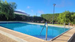 una piscina de agua azul en un patio en Los Candiles en Cantillana