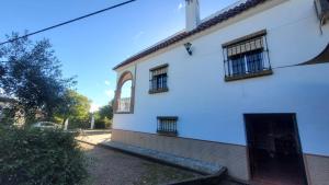 a white building with two windows and a door at Los Candiles in Cantillana