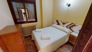 ein kleines Schlafzimmer mit einem Bett und einem Fenster in der Unterkunft CASA RURAL CON VISTAS ESPECTACULARES in Doña Rama + 27 Fotos