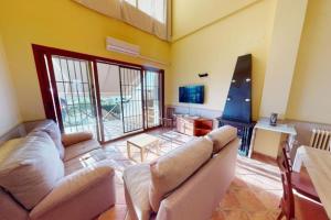 ein Wohnzimmer mit Sofa und Fernseher in der Unterkunft CASA RURAL CON VISTAS ESPECTACULARES in Doña Rama