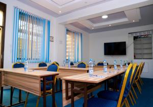 a conference room with tables and chairs and a flat screen tv at THE GEM HOTEL NAIVASHA in Naivasha