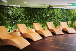 a row of wooden chairs in front of a green wall at Hotel Narvil Conference & Spa in Serock