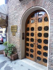 einen Eingang zu einem Backsteingebäude mit einer Holztür in der Unterkunft Albergo Reggio in Reggio nell'Emilia