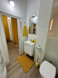 Un baño con inodoro, lavabo y espejo. en Paradise Suite Roma centro, en Roma