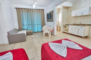 a kitchen and a living room with a table at Monte Libano Apart Hotel in Florianópolis