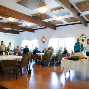 a group of people sitting at tables in a restaurant at Hotel Havlund Bed and Breakfast in Grenå