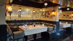 a restaurant with two tables and a tile wall at Sterlings Mac Hotel in Bangalore
