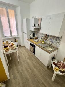 Una cocina con gabinetes blancos y una mesa con comida encima. en Paradise Suite Roma centro, en Roma 8 fotos más