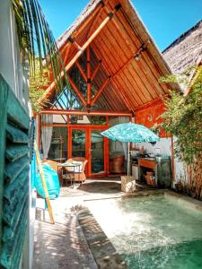 a house with a swimming pool and an umbrella at Sea Breeze Villas - Gili Air in Gili Air