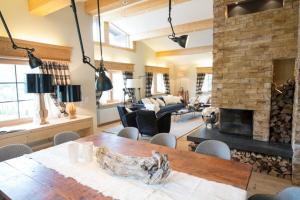 a living room with a table and a fireplace at Das Himmelhaus Sot il Pegn in Lenzerheide