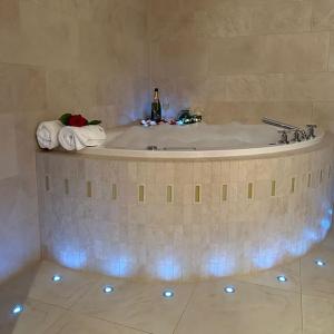 a bath tub in a bathroom with a bottle of champagne at Das Himmelhaus Sot il Pegn in Lenzerheide +14 photos