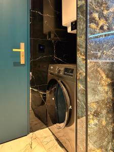 a washing machine in a bathroom next to a wall at Luxe appartement dichtbij centrum B in Drachten +10 photos