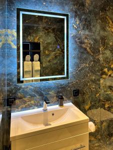 een badkamer met een wastafel en een spiegel bij Luxe appartement dichtbij centrum Drachten in Drachten