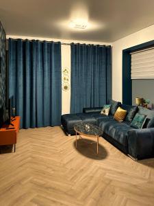 een woonkamer met een zwarte bank en een tafel bij Luxe appartement dichtbij centrum Drachten in Drachten