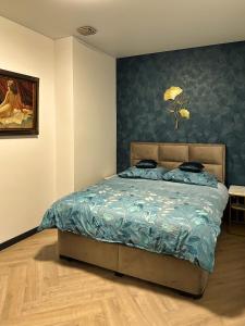 een slaapkamer met een bed met een blauw dekbed bij Luxe appartement dichtbij centrum Drachten in Drachten