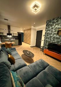 een woonkamer met een blauwe bank en een keuken bij Luxe appartement dichtbij centrum Drachten in Drachten