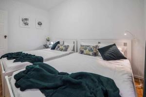 two beds with green blankets on them in a bedroom at Apart Lisboa confortavel 2 quartos com terraço in Odivelas