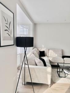 a white living room with a couch and a table at Private Luxury One Bedroom Apartment with parking in Palmers Green