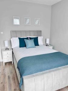 una camera da letto con un grande letto con cuscini blu di Private Luxury One Bedroom Apartment with parking a Palmers Green