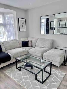 uma sala de estar com um sofá e uma mesa de café em vidro em Private Luxury One Bedroom Apartment with parking em Palmers Green