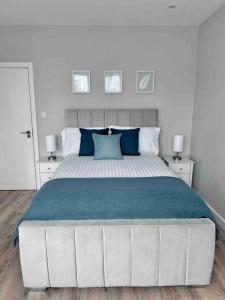een slaapkamer met een groot bed met blauwe kussens bij Private Luxury One Bedroom Apartment with parking in Palmers Green