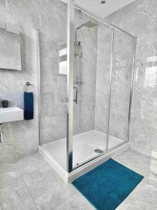 uma cabina de duche na casa de banho com um tapete azul em Private Luxury One Bedroom Apartment with parking em Palmers Green