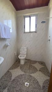 a bathroom with a toilet and a window at Amba Lodge Lalibela in Lalibela