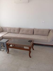 a living room with a couch and a coffee table at Zone touristique mahdia en face clinique rahma in Mahdia