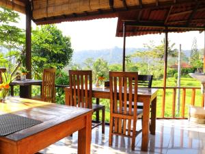 a dining room with a table and chairs with a view at Sweet Homestay in Sidemen