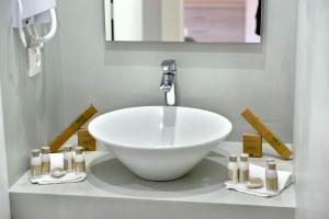 baño con lavabo blanco y espejo en Douskos Guesthouse en Hydra