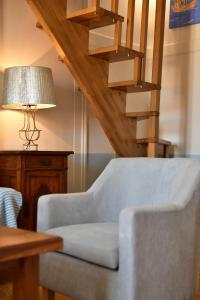 a living room with a chair and a staircase at Douskos Guesthouse in Hydra