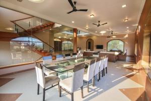 a dining room with a glass table and chairs at Akbar Villa 4BHK With Pool in Lonavala