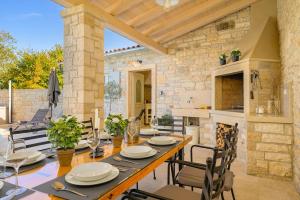 a dining room with a table and a stone wall at Villa Onelia by IstriaLux in Vodnjan