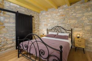 a bedroom with a bed and a stone wall at Villa Onelia by IstriaLux in Vodnjan +28 photos