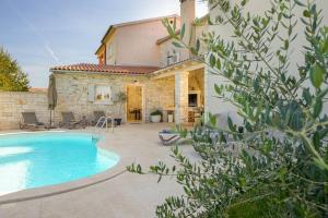 a villa with a swimming pool in front of a house at Villa Onelia by IstriaLux in Vodnjan