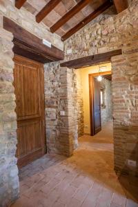a room with a stone wall and a wooden door at Abbazia San Pietro in Valle in Vagli