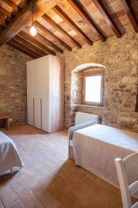 a bedroom with a bed in a stone wall at Abbazia San Pietro in Valle in Vagli