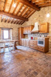 cocina grande con armarios de madera y mesa en Abbazia San Pietro in Valle, en Vagli