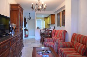 a living room with a couch and a table at Las Arenas-Islantilla-Huelva in Islantilla +10 photos
