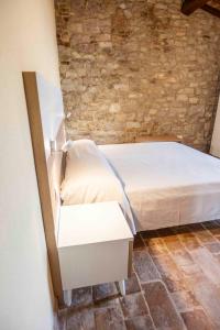 a bedroom with a bed and a stone wall at Abbazia San Pietro in Valle in Vagli