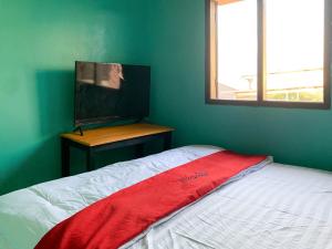 a bedroom with a bed with a red blanket on it at RedDoorz @ Langkapura Lampung in Kedaton