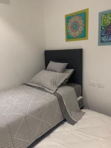 1 cama con edredón blanco y negro en una habitación en str_on 5, en Encarnación