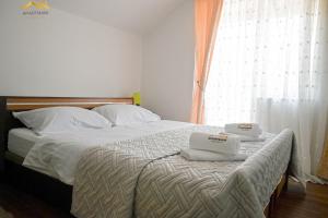 a bedroom with a bed with two towels on it at Apartmani Jaguzovic in Mrkonjić Grad