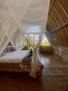 a bedroom with a bed with a canopy at Vertical House Bali in Uluwatu