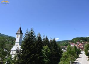 a church on a hill with trees at Apartmani Jaguzovic in Mrkonjić Grad