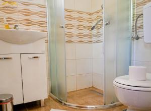 a bathroom with a shower and a toilet and a sink at Apartmani Jaguzovic in Mrkonjić Grad