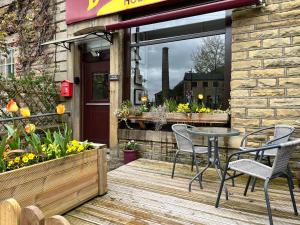 a patio with chairs and a table on a wooden deck at Royd Villas Central Hebden Bridge in Hebden Bridge