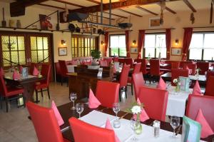 a dining room with tables and red chairs at Landhotel Zur Post in Bad König