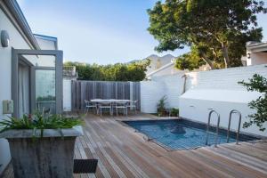 a patio with a table and a swimming pool at Leopard Tree Cottage in Franschhoek